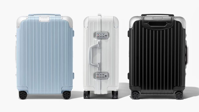 RIMOWA Hybrid Suitcase Collection in Gloss Sky Blue, Gloss White, and Matte Black with aluminum corners and polycarbonate shell, designed for premium travel.