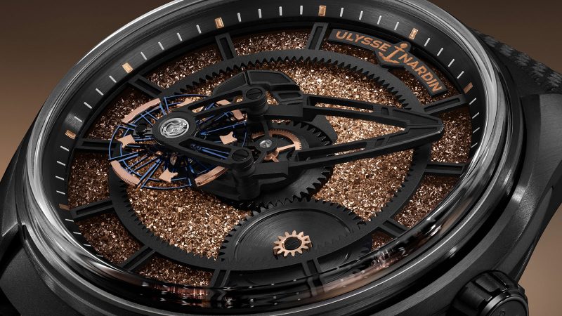 Ulysse Nardin Freak X Crystalium watch with black DLC titanium case, unique ruthenium crystal dial, and rose-gold accents on ballistic-textured strap.