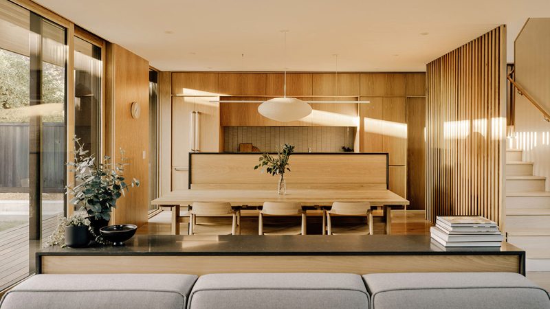 Cupertino Courtyard House exterior by SHED Architecture, featuring white stucco walls and charred-wood upper volume surrounded by lush courtyards.