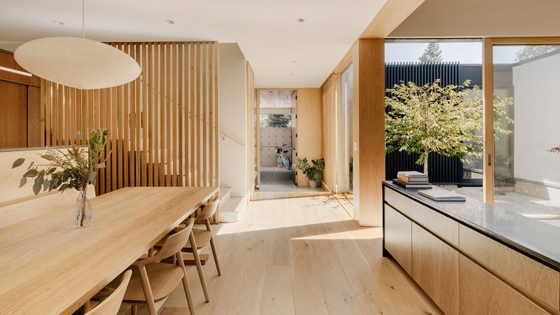 Cupertino Courtyard House exterior by SHED Architecture, featuring white stucco walls and charred-wood upper volume surrounded by lush courtyards.
