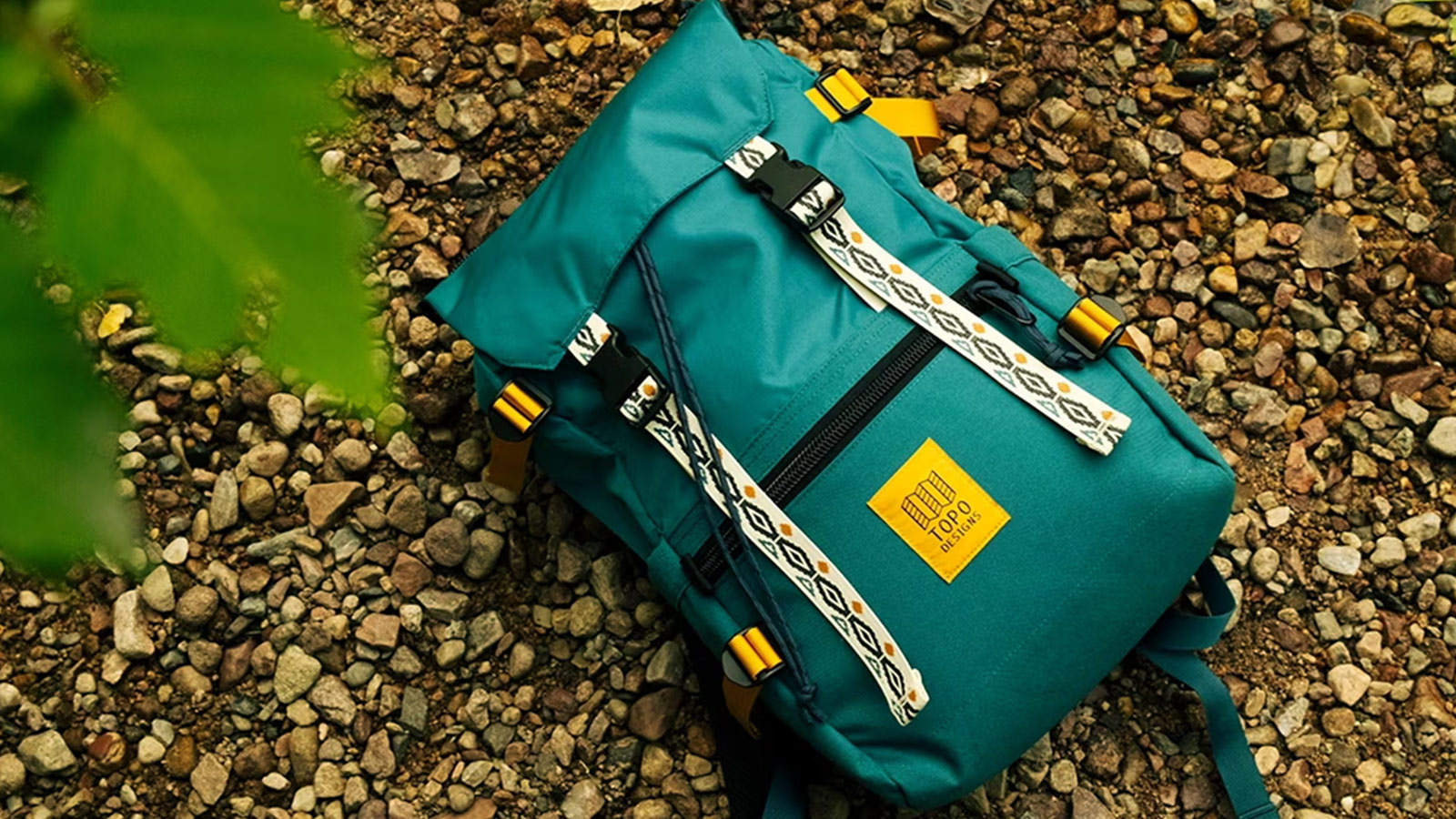 Rugged teal Topo Designs daypack with secure straps and bold design, built for fall trail-to-town gear.
