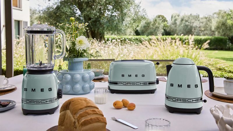 The limited-edition Porsche × Smeg appliances lineup boasts bold racing stripes—featuring a fridge and coffee machine in motorsport styling.
