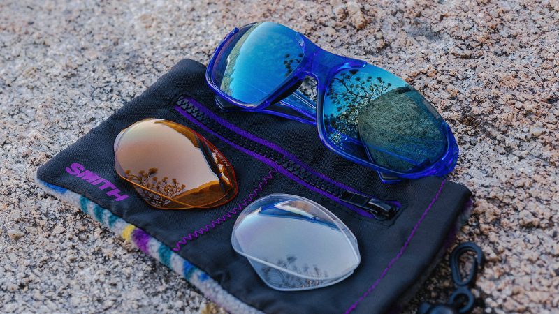 The Smith Optics Sliders sunglasses with interchangeable lenses, wraparound 8-base frame, ChromaPop™ black sun lens installed, amber low-light and clear lenses shown, matte olive finish.