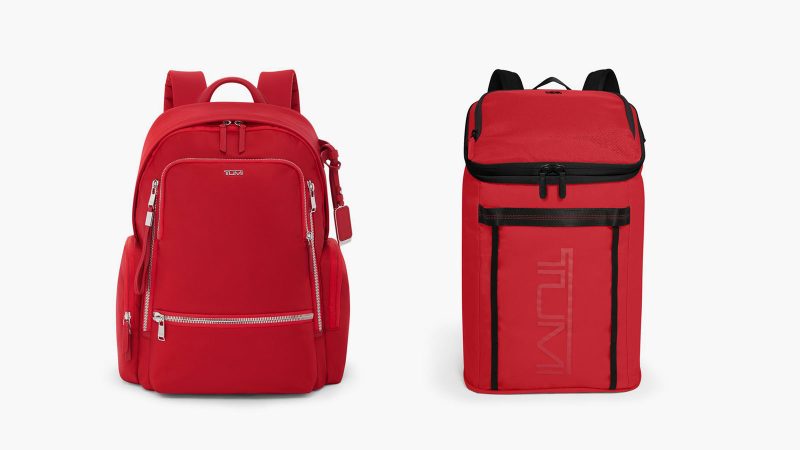 TUMI’s “Gift Joy” campaign features classic TUMI Red and Black luggage pieces—including the 19 Degree Aluminum Carry-On and Celina Backpack—stacked and tied with a festive red ribbon.