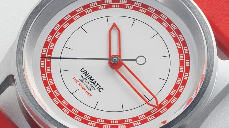 Unimatic x The Armoury Modello Cinque U5S-TA2 “10.15” watch with red and white dial accents, black hour ring, and red TPU strap.