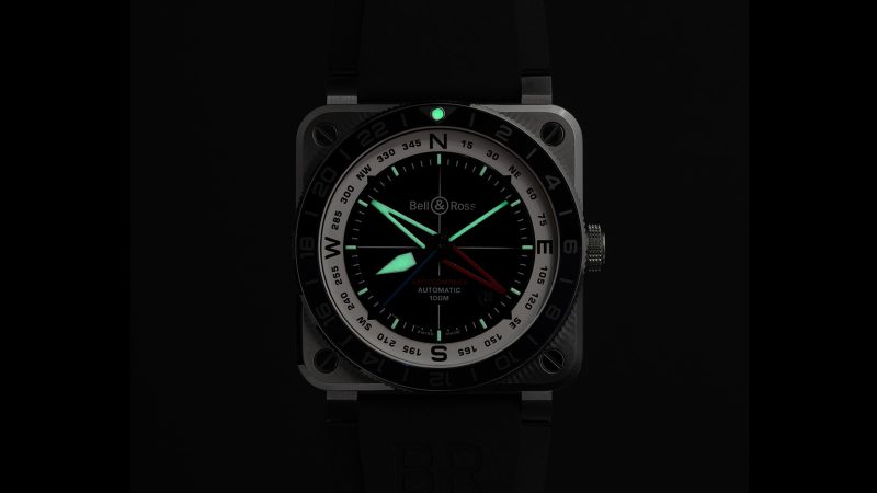 The Bell & Ross BR-03 GMT Compass watch with a square steel case, a black dial, a dual-color 24-hour bezel, and a red GMT hand.