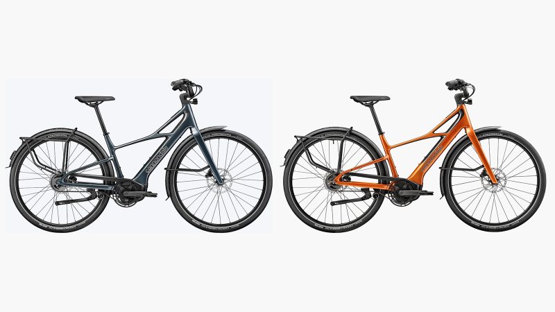 The Cannondale FlyingV carbon e-bike with V-frame design, carbon fenders, and belt-drive system displayed in an urban setting.