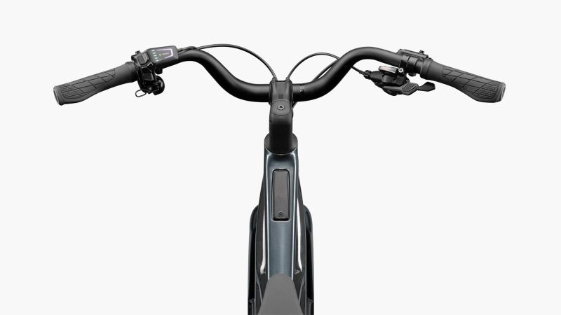 The Cannondale FlyingV carbon e-bike with V-frame design, carbon fenders, and belt-drive system displayed in an urban setting.