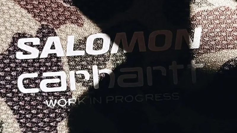 The Carhartt WIP x Salomon X-ALP is a black leather and synthetic trail sneaker with duck camo collar, rubber mudguard, and Utilitarian workwear flair.