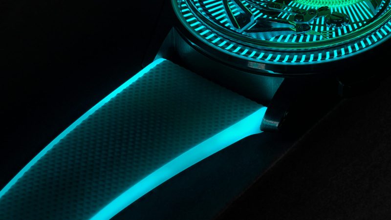 Christopher Ward’s C1 Bel Canto Lumière glowing titanium watch with luminous dial, blue accents, and white Super-LumiNova strap.