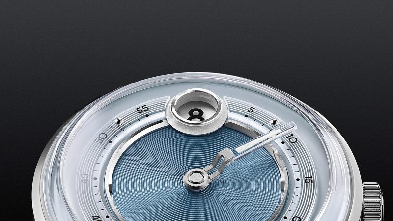 The Christopher Ward C1 Jump Hour Mk V watch with a glowing sapphire dial ring and jump hour display in Noon Blue.