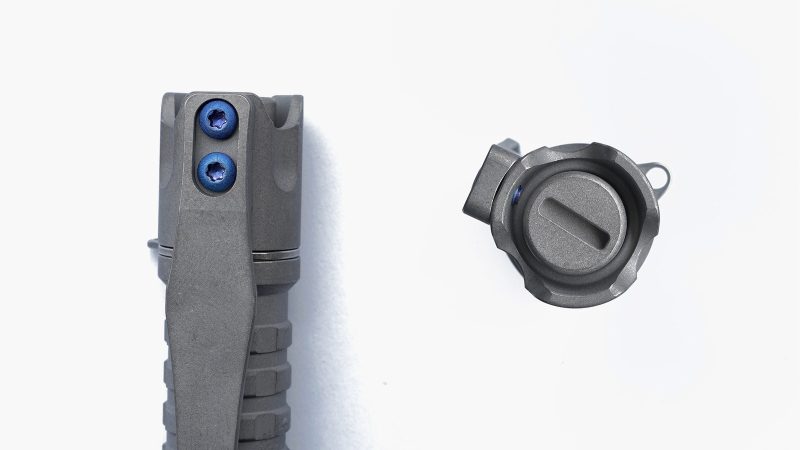 ReyLight Pineapple Mini MKIII Titanium Flashlight featuring a reverse clicky switch, titanium clip, and 4000K Nichia LED, showcased on a dark EDC gear setup.