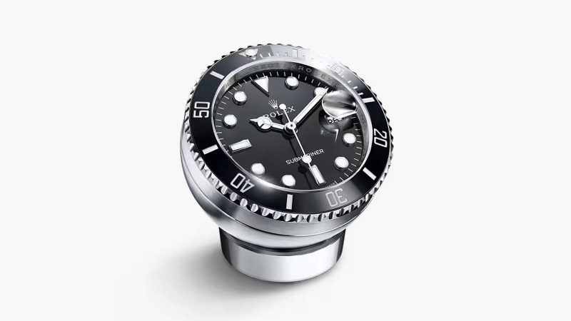 The Rolex Submariner Date Desk Clock with a Cerachrom-style bezel, a sapphire crystal, and a Cyclops lens.