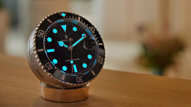 The Rolex Submariner Date Desk Clock with a Cerachrom-style bezel, a sapphire crystal, and a Cyclops lens.