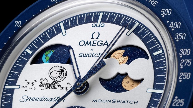 Navy SWATCH x Omega Mission to Earthphase Moonshine Gold Beaver Moon Edition watch with Earthphase, Moonshine Gold moonphase, Snoopy detail, and Bioceramic case.