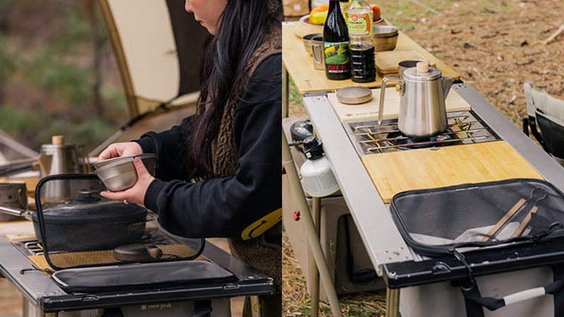 Snow Peak Iron Grill camp kitchen and table setup outdoors features modular stainless steel cooking units and a wooden tabletop for outdoor dining.