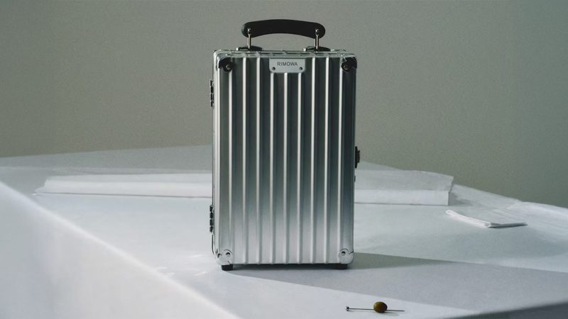 The RIMOWA x Robbe & Berking Cocktail Case features an aluminum shell, handcrafted silver bar tools, and a luxe travel mixology setup.