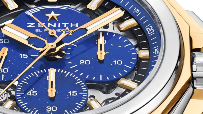 The Zenith DEFY Extreme Lapis Lazuli watch features a 45mm steel case with gold accents, a lapis stone dial, an openworked El Primero 9004 movement, and an included strap set.