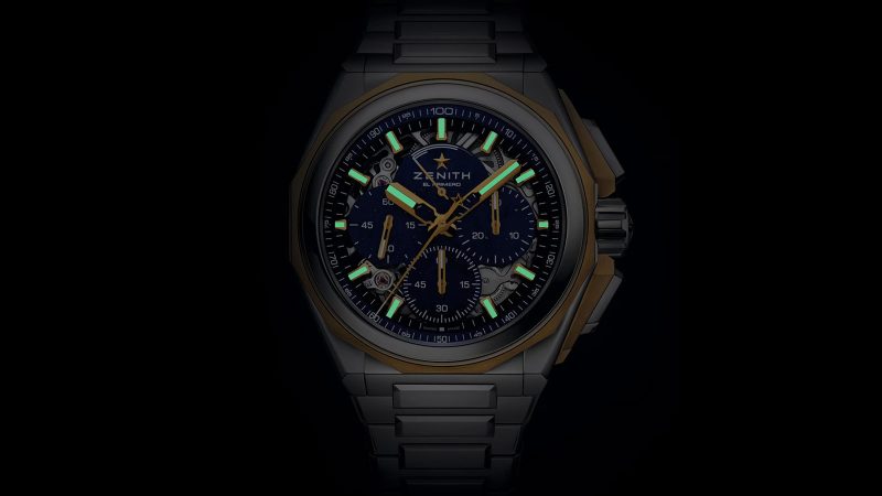 The Zenith DEFY Extreme Lapis Lazuli watch features a 45mm steel case with gold accents, a lapis stone dial, an openworked El Primero 9004 movement, and an included strap set.