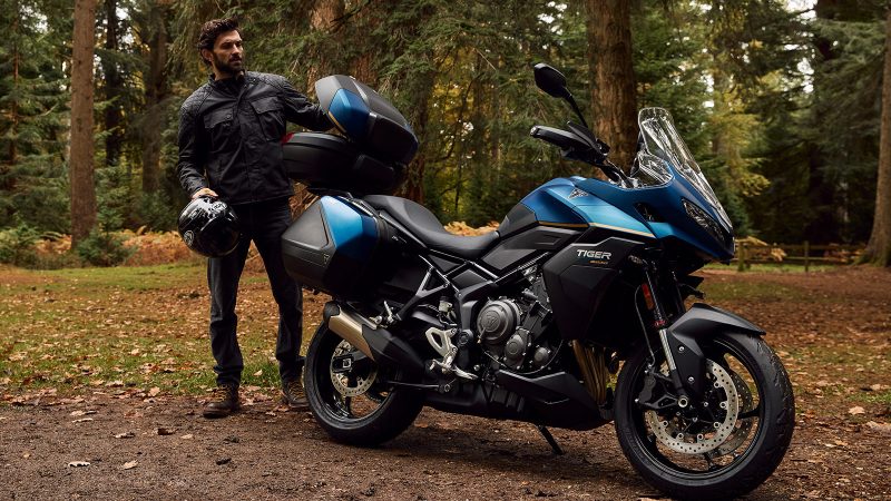 The 2026 Triumph Tiger Sport 800 Tour motorcycle with panniers, top case, 798cc triple engine, touring accessories, heated grips, comfort seat, TPMS, and Showa suspension.