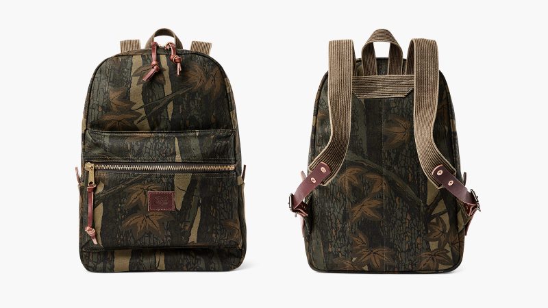 The Filson Workshop Rugged Twill Backpack in Maple Bark Camo with Harness Leather straps, brass zippers, padded back panel, and 15-inch laptop sleeve.