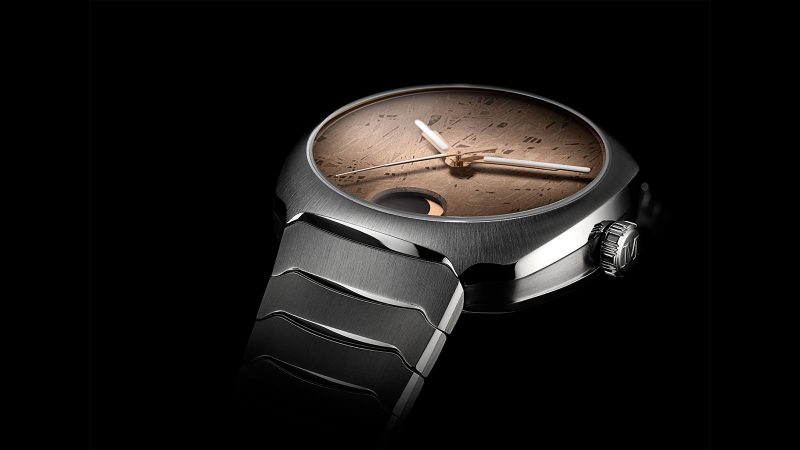 The H. Moser & Cie. Streamliner Perpetual Moon Concept Meteorite watch with a golden Gibeon meteorite dial, steel integrated bracelet, and moon phase at 6 o'clock.