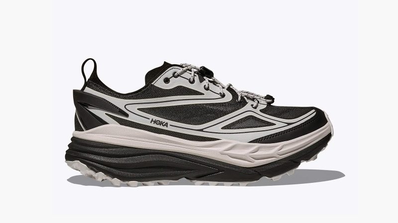 The HOKA Stinson One7 Dover Street Market collaboration sneaker features maximal cushioning, monochrome design, all-terrain sole, and high-fashion trail aesthetic.