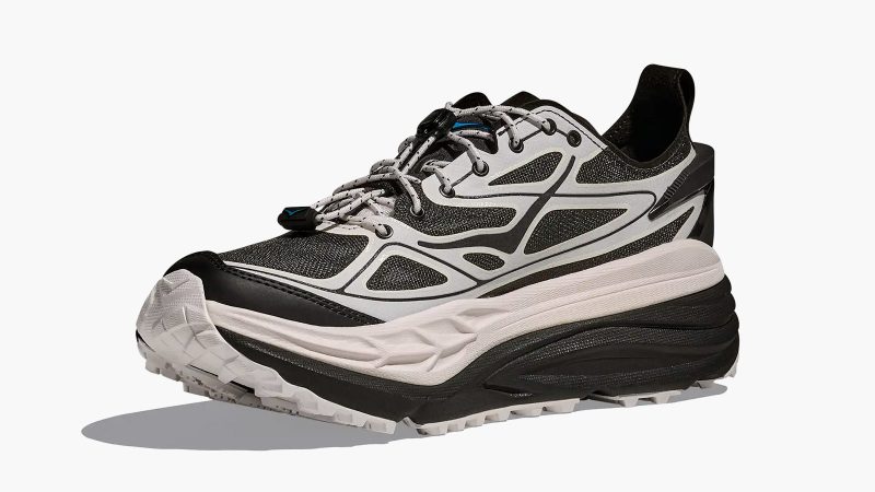 The HOKA Stinson One7 Dover Street Market collaboration sneaker features maximal cushioning, monochrome design, all-terrain sole, and high-fashion trail aesthetic.