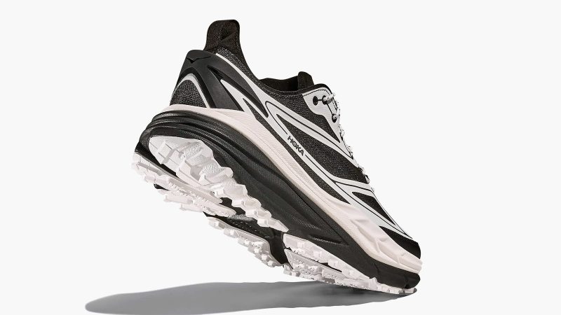 The HOKA Stinson One7 Dover Street Market collaboration sneaker features maximal cushioning, monochrome design, all-terrain sole, and high-fashion trail aesthetic.