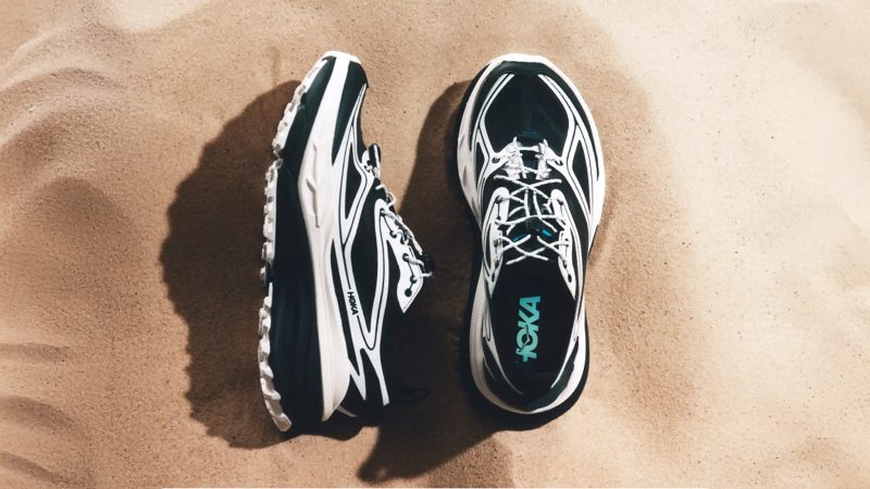 The HOKA Stinson One7 Dover Street Market collaboration sneaker features maximal cushioning, monochrome design, all-terrain sole, and high-fashion trail aesthetic.