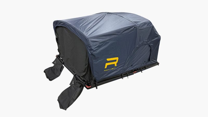 The Roofnest Meadowlark ultralight rooftop tent is mounted on a compact SUV, featuring an open fold-out design with an integrated ladder and foam mattress.