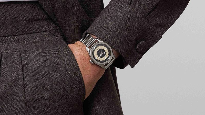 The Serica 6190 TXD watch with a black and beige tuxedo dial, stainless steel case, COSC chronometer automatic movement, and minimalist French watch design.