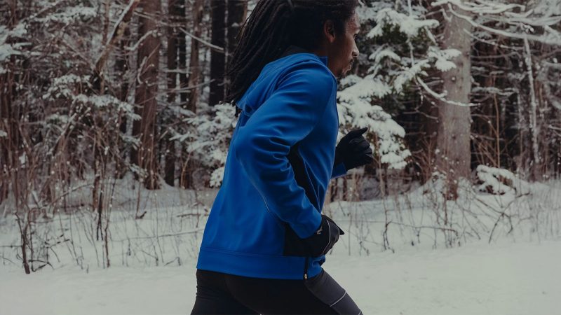 Tracksmith’s NDO Anorak winter running jacket with Merino wool lining, Schoeller softshell exterior, adjustable hood, 360-degree reflectivity, and technical cold-weather design.