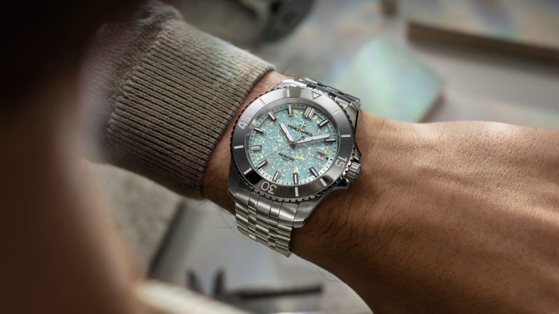 The Venezianico Nereide Opale watch features a shimmering iridescent lab-grown opal dial, gray tungsten bezel, and 42mm stainless steel case.